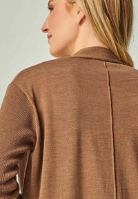 Brauner gestrickter Cardigan mit einem gerippten Muster, Schalkragen und einer zentralen Nahtdekoration, von hinten gezeigt mit langen Ärmeln.