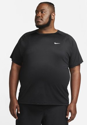 Black short-sleeve athletic shirt with a textured fabric and round neckline; features a small white Nike logo on the upper left side.