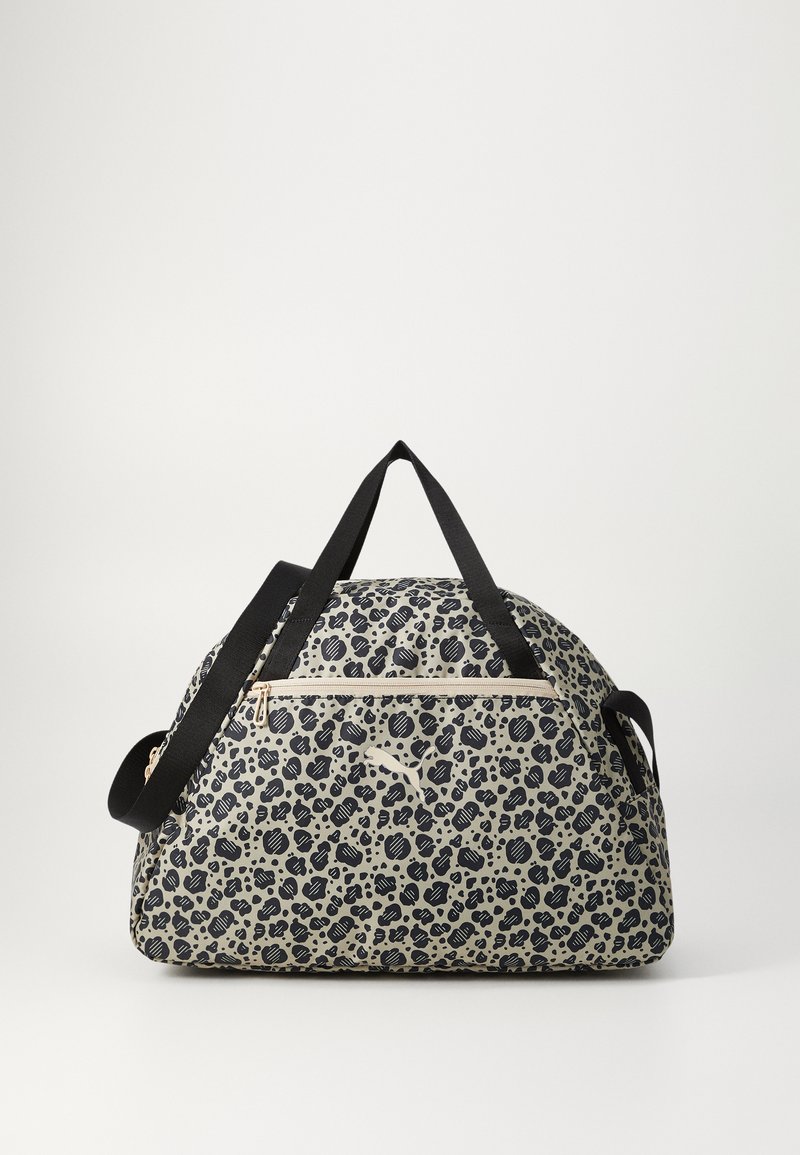 Czarna i beżowa torba podróżna w leoparda z teksturowanej tkaniny, podwójnymi czarnymi uchwytami i złotym zamkiem błyskawicznym na przedniej kieszeni.