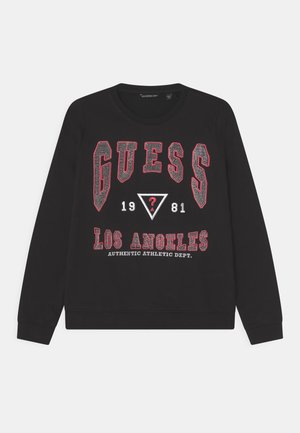 Czarny sweatshirt z długimi rękawami, z wyraźnym czerwonym i białym napisem "GUESS", trójkątami oraz napisem "LOS ANGELES" w detalach druku.