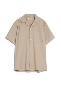 Camicetta a maniche corte di colore beige, realizzata in lino. Presenta un colletto a puntone, una tasca frontale e cinque bottoni sul davanti.