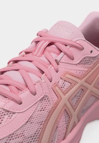 Ροζ αθλητικό παπούτσι με επάνω μέρος από δίχτυ, συνθετικά επικαλύμματα, κορδονάκια και λογότυπο στο πλάι και στη γλώσσα.