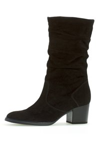 Svart mocka ankelsko med en slouchy design, rund tå och en grov klack. Har subtila sömnadsdetaljer längs sidorna.