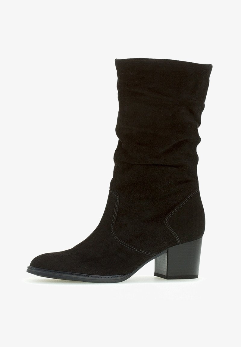 Svart mocka ankelsko med en slouchy design, rund tå och en grov klack. Har subtila sömnadsdetaljer längs sidorna.