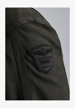 Donkergroene leren jas met een gestructureerd oppervlak en een prominente zwarte geborduurde patch met vleugels en de tekst "PME 1649-A."