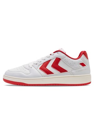 White sneaker with red accents, featuring smooth leather, perforated toe, and a textured rubber sole. Includes a logo on the side.