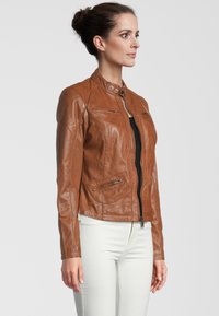 Braune Leder-Motorradjacke mit tailliertem Design, hohem Kragen, zwei Reißverschlusstaschen auf der Brust und seitlichen Taschen, strukturierte Oberfläche.