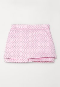 Mini-jupe rose avec motifs géométriques et floraux blancs, avec un design en couches et des poches latérales.
