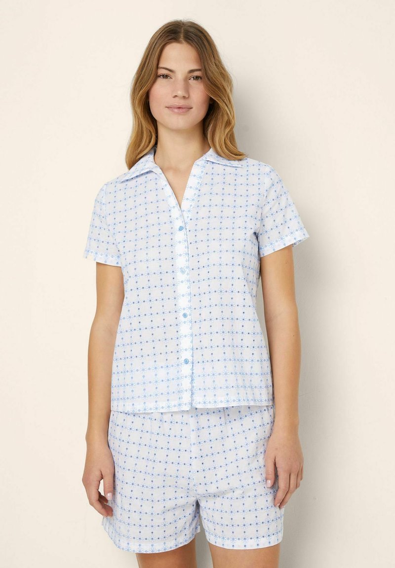 Blå kortärmad skjorta och shorts-set i ett lätt, mönstrat tyg med ett rutmönster och små blå detaljer. Knappstängning på skjortan.