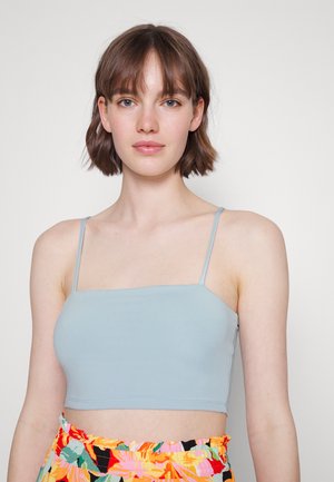 Top cropped azul claro com alças finas, feito de um tecido suave. Design simples com um decote reto e forma ajustada.