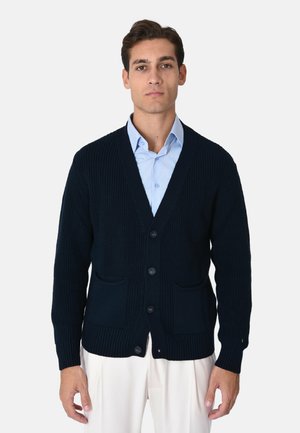 Cardigan lavorato a maglia blu navy con scollo a V, sei bottoni e due tasche frontali. Polsini e orlo a costine, realizzato in tessuto strutturato.
