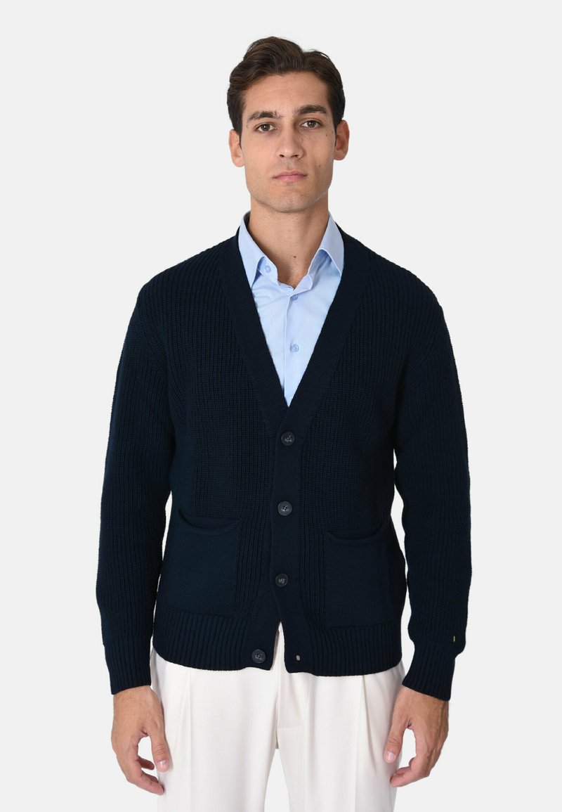 Cardigan lavorato a maglia blu navy con scollo a V, sei bottoni e due tasche frontali. Polsini e orlo a costine, realizzato in tessuto strutturato.