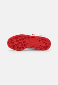 Sole in gomma rossa con motivo battistrada circolare e grip testurizzato. La parte superiore è realizzata in materiale bianco con accenti rossi e lacci.