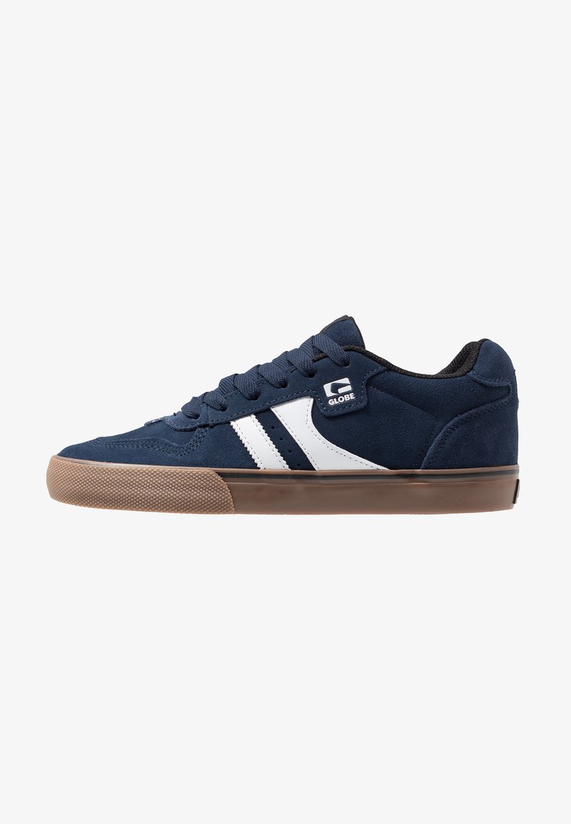 Navyblaue Wildledersneaker mit weißen Streifen, runder Spitze, flacher brauner Gummisohle und schwarzem Innenpolster. Verfügt über Schnürsenkel und ein Logo an der Seite.
