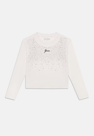 Hvid langærmet croppet top med spredte små sølvnitter og sort "Guess" logo i midten af brystet.