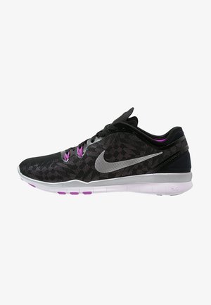 Chaussure de course Nike noire et grise avec des accents violets, une semelle blanche, une tige en mesh et un logo swoosh argenté sur le côté.
