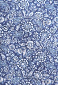 Denso motivo di tessuto floreale e paisley blu e bianco con intricate foglie e motivi di fiori che si avvolgono.