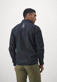 Svart lett jakke med stående krage, med en logo på ryggen, laget av glatt, vannavvisende materiale.