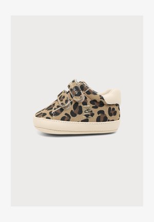 Kindersneaker met beige en zwart luipaardprint, twee klittenbandsluitingen, witte zool en witte hielpatch, zijaanzicht op effen achtergrond.