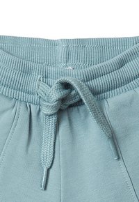 Hellblauer elastischer Bund mit einer gebundenen, flachen, geflochtenen Kordel an lässigen Baumwollhosen oder -shorts.