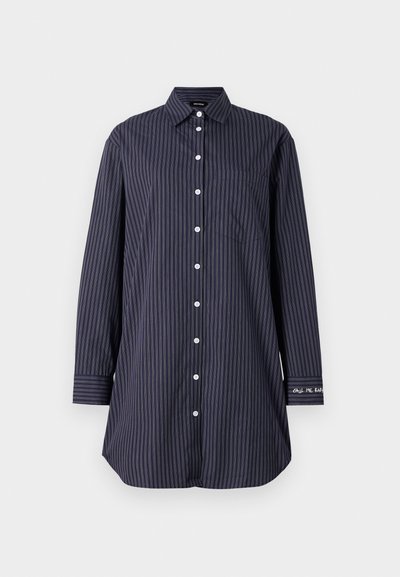 Camisa de uniforme azul marino con rayas verticales, mangas largas, cuello clásico, un bolsillo en el pecho y detalle de texto en la manga.