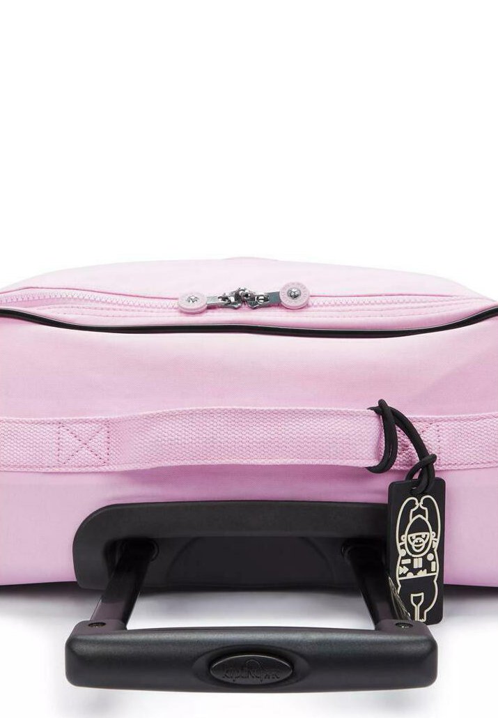 Bolso de viaje rosa con un Asa retráctil negra, cierre de cremallera, tejido texturizado y una etiqueta con un personaje de dibujos animados.