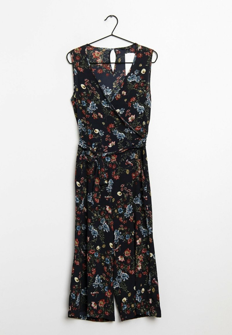 Jumpsuit floral en bleu marine foncé avec des motifs de fleurs rouges et bleues. Il présente un design enroulé, une coupe sans manches et une ceinture à nouer à la taille.