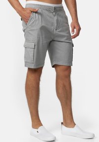 Shorts cargo gris avec une taille élastique, des poches latérales et un design avant plat. Fabriqués en tissu léger, idéaux pour une tenue décontractée.