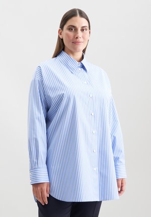 Chemise boutonnée rayée bleu clair avec un col classique, des manches longues et des boutons blancs ; présente une coupe décontractée et un ourlet arrondi.