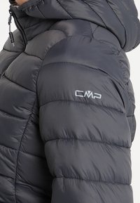 Chaqueta acolchada de color gris oscuro con diseño entallado, patrón acolchado horizontal y logotipo CMP en la manga. Cuenta con cuello alto y cierre de cremallera.