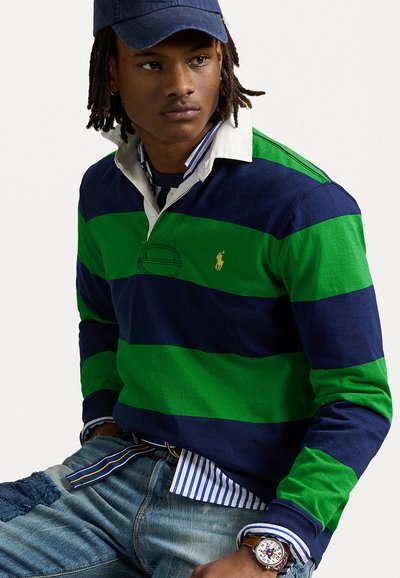 Green and navy striped long-sleeve polo shirt with a white collar. Worn with a blue and white striped shirt underneath and denim jeans.