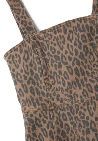 Prenda de estampado de leopardo con una combinación de colores marrón y negro, hecha de una tela texturizada con tirantes y detalles de costura visibles.