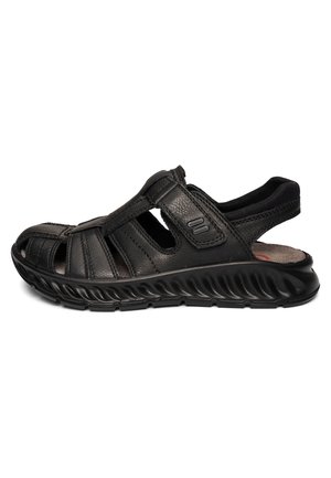 Black leather men's sandal with closed toe, open sides, padded heel strap, and thick textured sole for casual wear.
