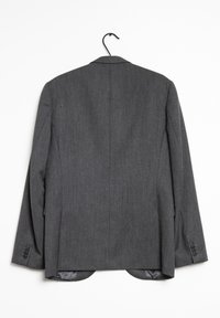 Grå skräddarsydd Blazer med en slät yta, enkelradig design, slagkrage och fyra knappar på varje ärm. Hänger på en krok.