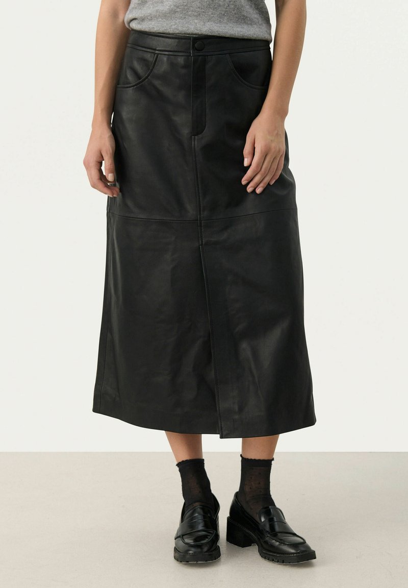 Black leather midi skirt with front seam detail and two pockets. Features a fitted waist and a straight silhouette, paired with black loafers.