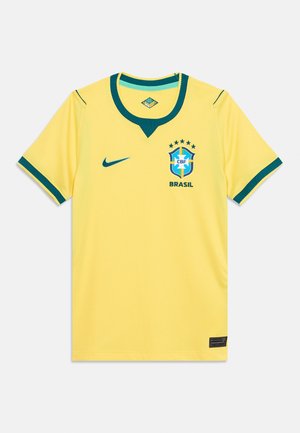 Rumena Brazilija nacionalna nogometna majica z zelenim ovratnikom in manšetami, logotipom Nike in grbom Brazilije s petimi zvezdami na prsih.