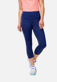 Leggings capri navy avec une taille haute et des poches latérales, fabriquées dans un tissu extensible, accompagnées d'un haut de sport rose à motifs.