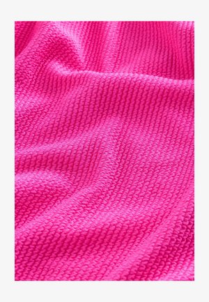 Texturált szövet élénk rózsaszínben, bordázott mintával. Puha és pelyhes megjelenés, finom fényességgel a szőtt szálaktól.