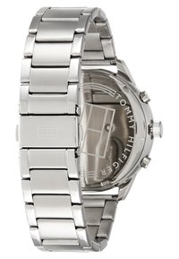 Silberne Edelstahl-Uhr mit linked Armband, runder Gehäuseform und klarem Glas, ausgestattet mit einem minimalistischen Ziffernblatt und Logo auf der Rückseite.