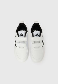 Valged spordijalatsid mustade detailidega; neil on sile sünteetiline pealne, hingav võrgust vooder, reguleeritavad takjapaelad ja tekstureeritud tald.