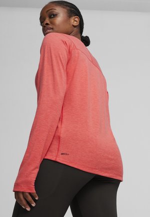 Long-sleeve athletic top in heathered coral fabric with flat seams and thumbholes, featuring a "DRYCELL" logo at the hem.