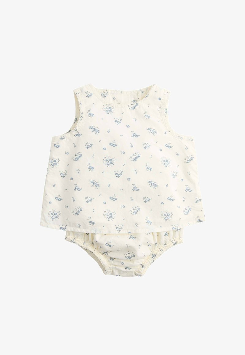 Vestido de bebé sin mangas de color crema y bombacho a juego con pequeño estampado floral azul y aberturas elásticas en las piernas.
