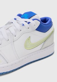 Vita lädersneakers med blå detaljer, mesh-tunga och grön genomskinlig swoosh. Har en texturerad sula med blå gummidetaljer.