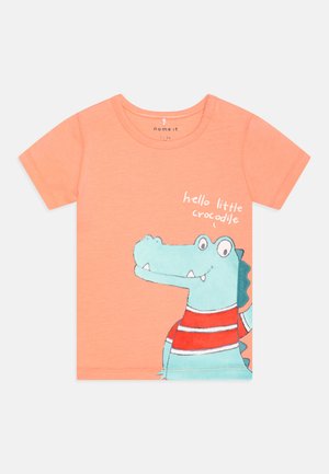 Krátky rukáv oranžové tričko vyrobené z bavlny, s grafikou modrého krokodíla v červenom prúžkovanom tričku a textom "ahoj malý krokodíl".