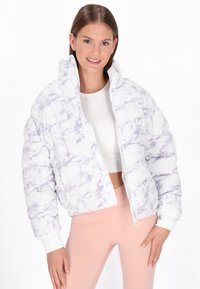 White and lavender marble-patterned puffer jacket with a zip front, high collar, and ribbed cuffs, worn over a white top and pink leggings.