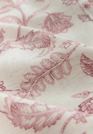 Ljust tyg med en krämfärgad bakgrund och ett invecklat blommönster i mjuk rosa. Texturen verkar slät med subtila variationer.