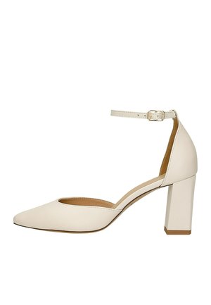 Beige gesloten hoge hakken met een blokhak en een smalle enkelriem met gespsluiting.