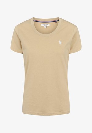 Beżowa bawełniana koszulka z okrągłym dekoltem, krótkimi rękawami i małym białym haftowanym logo na lewej piersi. Gładka faktura, luźny krój.