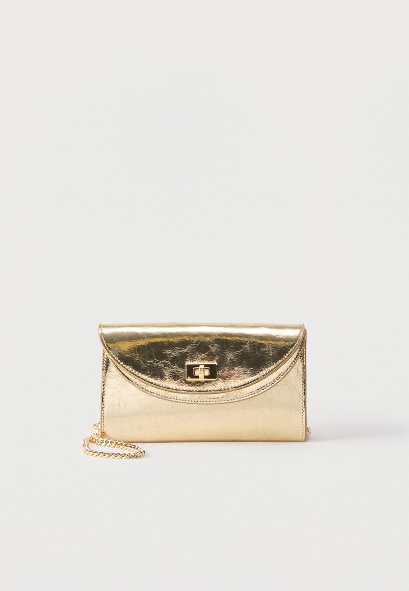 Μικρό μεταλλικό χρυσό πορτοφόλι χειρός με καμπυλωτό καπάκι και κούμπωμα με περιστρεφόμενο κλείδωμα, διαθέτει κοντό χρυσό αλυσίδα λαβής.