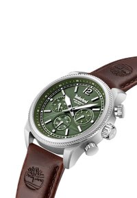 Strieborné hodinky z nehrdzavejúcej ocele so zeleným ciferníkom, hnedým koženým remienkom a tromi subciferníkmi. Majú textúrovaný ciferník a vyrytý logotyp.